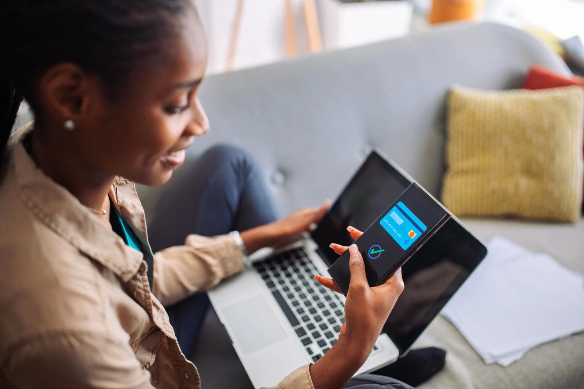 A parent using a tablet for a digital payment alongside a laptop
